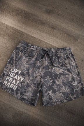The Tango Charlie Apparel Men's Mesh Lifestyle Shorts | 5.5"- Lift Heavy Pray Hard Deadwood feature gray camo, black drawstrings, and "LIFT HEAVY PRAY HARD" in white—perfect mesh shorts for an active lifestyle.