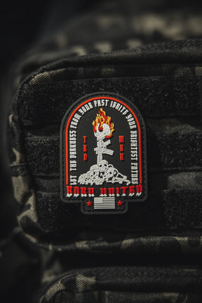 The Let The Darkness PVC Patch by Born United Private Label features a fiery torch above skulls and bones with BORN UNITED and phrases encircling the torch, all set on textured black fabric.