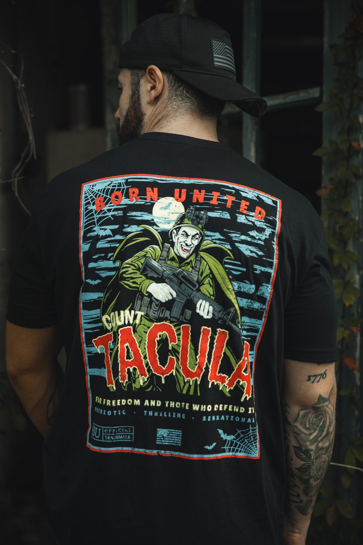 A man wears the Born United Private Label “Count Tacula” tee, a limited edition black Halloween shirt with a vivid vampire-and-gun graphic under a full moon. The back features “Born United,” “Count Tacula,” and extra slogans.