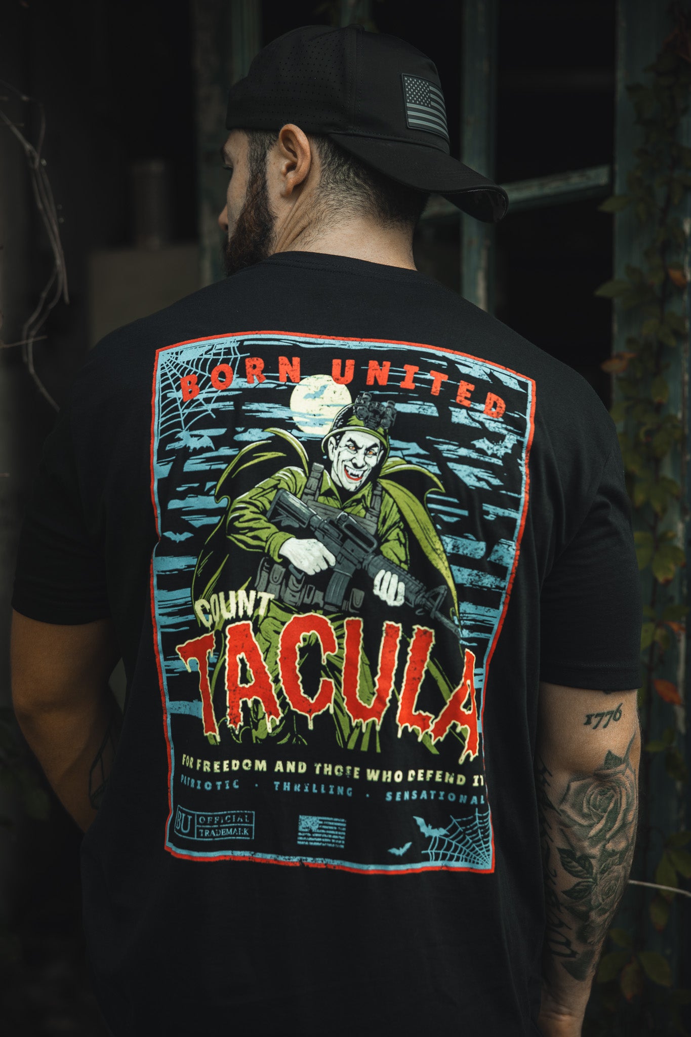 A man wears the Born United Private Label “Count Tacula” tee, a limited edition black Halloween shirt with a vivid vampire-and-gun graphic under a full moon. The back features “Born United,” “Count Tacula,” and extra slogans.
