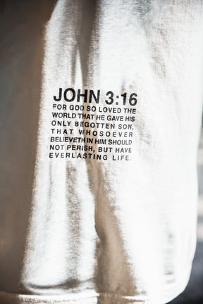Close-up of the 13th Jesus Saves - White Tee, showcasing John 3:16 in bold black text: "For God so loved the world that he gave his only begotten son, offering everlasting life to all who believe in him.