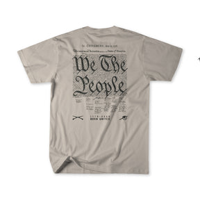 The Born United Patriot Box tee by Born United Private Label features a beige color, large "We The People" script, Constitution-style text, and small symbols and wording—including scissors, an eye, and BORN UNITED—on the back. Limited Edition.