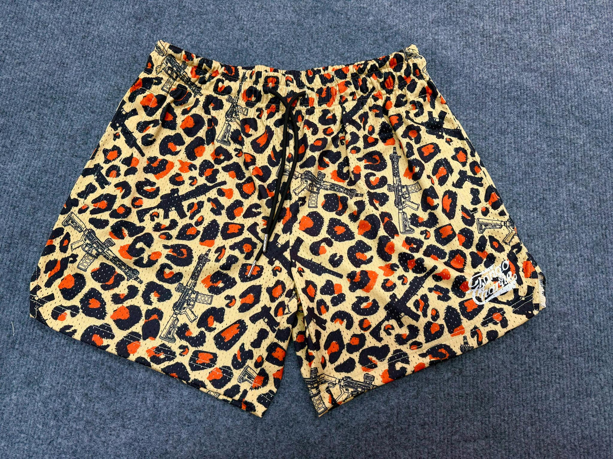 The Tango Charlie Apparel Men's Mesh Lifestyle Shorts | 5.5" - Loaded Leopard feature a bold yellow, orange, and black leopard print with black rifle graphics—perfect for standout style and breathable comfort.