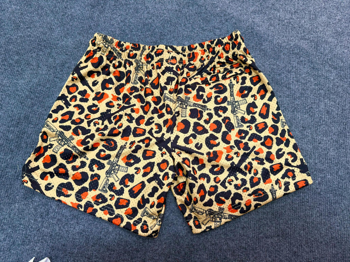 Tango Charlie Apparel Men's Mesh Lifestyle Shorts | 5.5"- Loaded Leopard are unisex workout shorts with a yellow, orange, and black leopard print and small Eiffel Tower motifs, shown laid flat on a gray carpet.