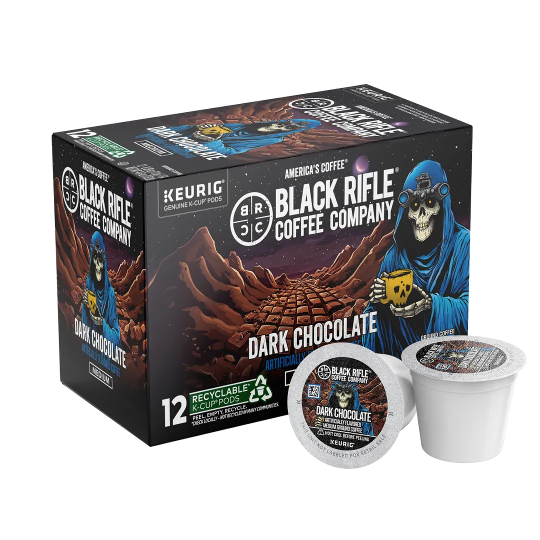 A box of Black Rifle Coffee Dark Chocolate Blend Coffee Rounds shows a skeleton in a blue hood with coffee before a desert background, with two Keurig compatible pods displayed in front.