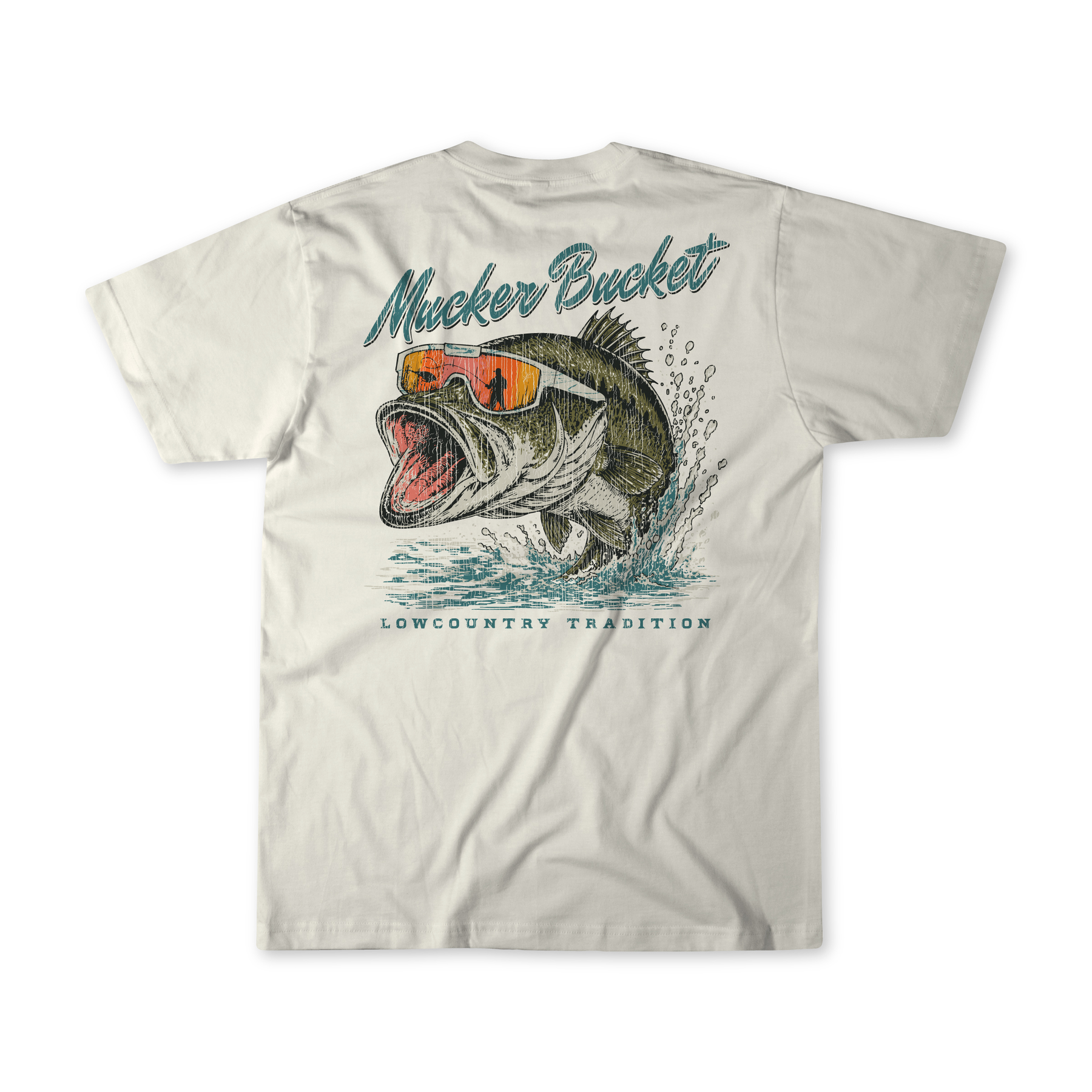 Introducing the Cool Bass Premium Tee by Mucker Bucket—a white t-shirt featuring a striking graphic of a leaping fish in orange sunglasses. “Mucker Bucket” is printed above the image, with “Lowcountry Tradition” below. Made from soft ring-spun cotton for a relaxed fit, this stylish tee seamlessly blends comfort and coastal vibes.