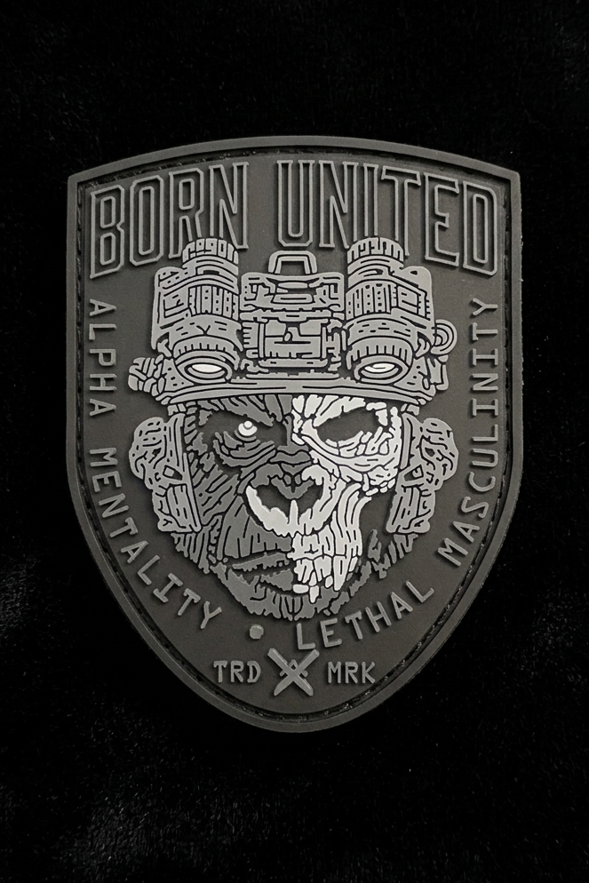 The Alpha Mentality PVC Patch by Born United Private Label features a dark shield with a snarling animal skull in night vision goggles, boldly displaying "Alpha Mentality" and "Lethal Masculinity," encircled by "Born United" and "TRD MRK.