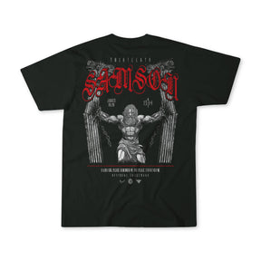 The 13th Samson Premium Tee is a black t-shirt with an illustration of Samson breaking pillars, “SAMSON” in bold red Gothic letters above, and biblical references along with details in white text below.