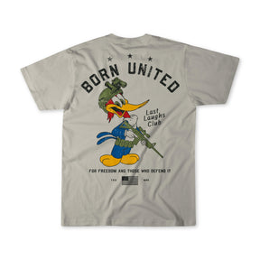 The Last Laughs Club Tee by Born United Private Label is a light gray shirt featuring a cartoon woodpecker in military gear with rifle, and the phrases BORN UNITED, Last Laughs Club, and For freedom and those who defend it on the back.